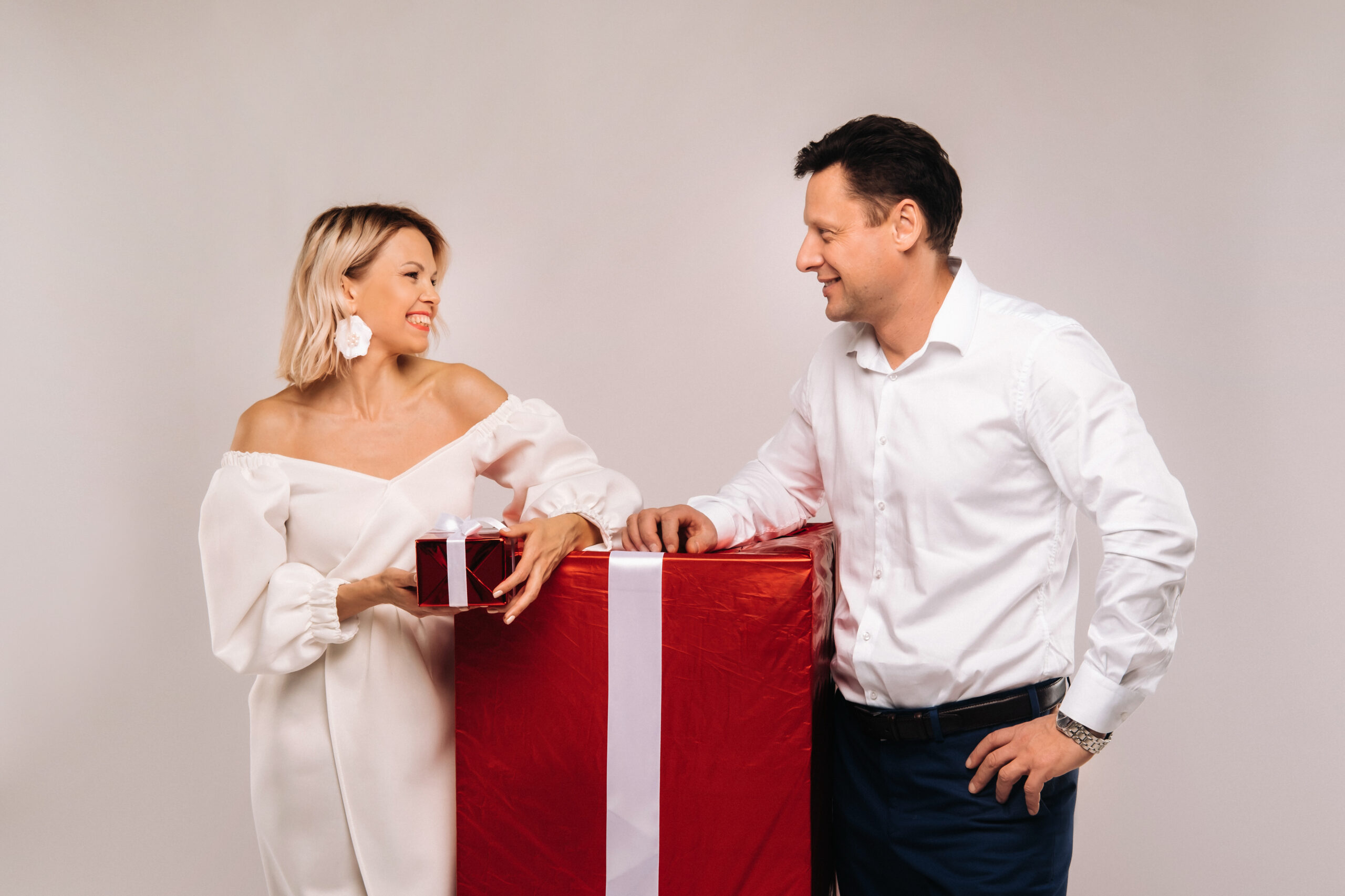 Homem e Mulher vestidos de Branco e recebendo um presente de casamento.